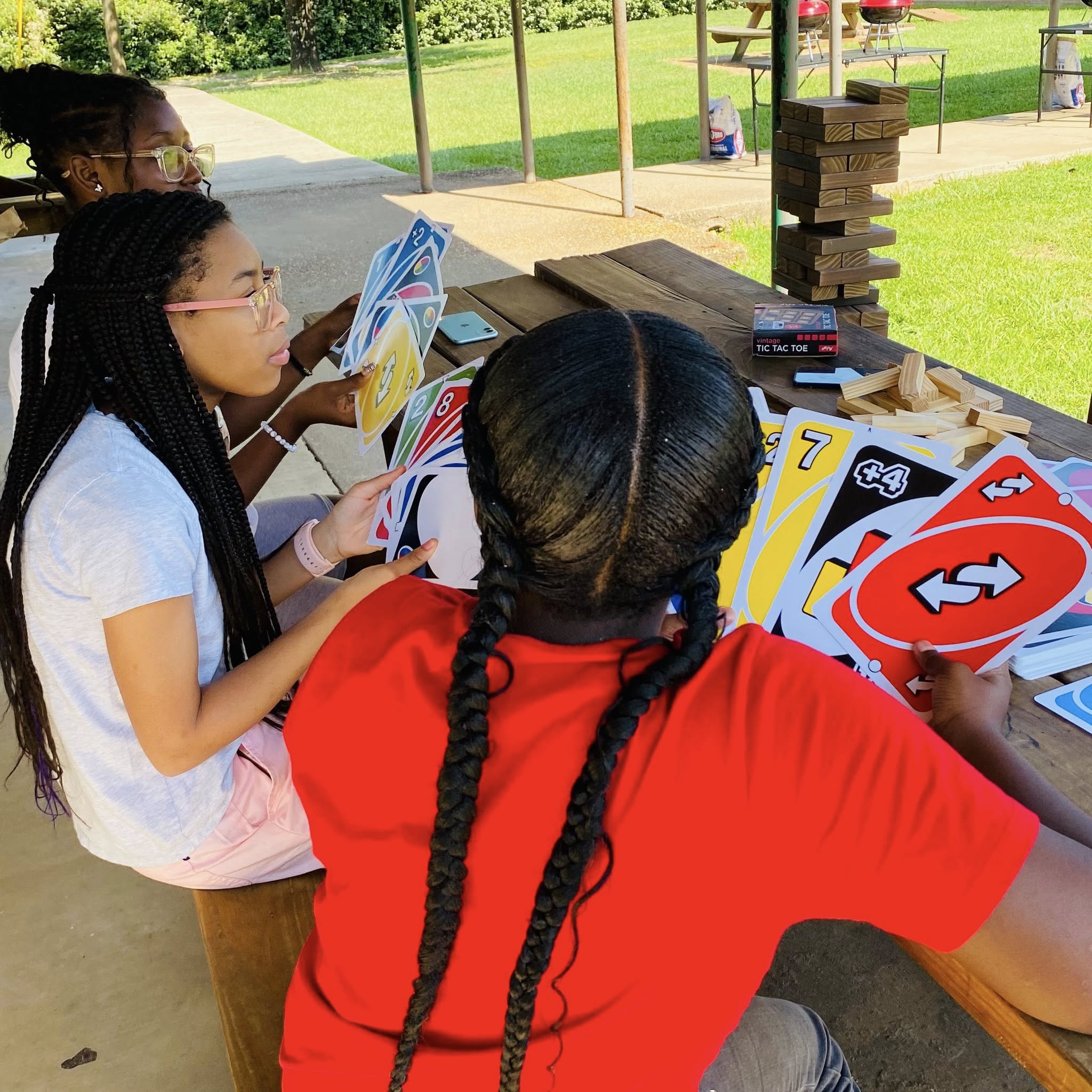 Two girls holding giant Uno cards.